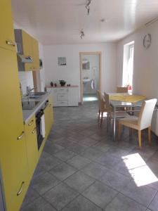 eine Küche und ein Esszimmer mit einem Tisch und gelben Schränken in der Unterkunft Apartment Sayda 4 in Pilsdorf
