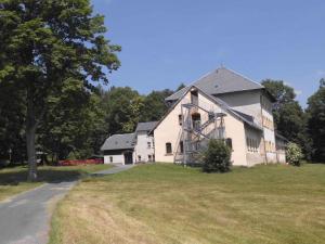 a large white barn with a tree and a road at Apartment Sayda 4 in Pilsdorf