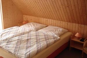 a bed in a room with a wooden ceiling at Apartment Neuendorf - Hiddensee 2 in Neuendorf