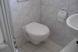een witte badkamer met een toilet en een wastafel bij Apartment Neuendorf - Hiddensee 2 in Neuendorf