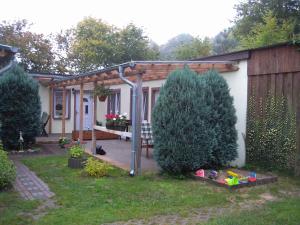 einen Garten mit einer Pergola neben einem Haus in der Unterkunft Apartment Kamminke 3 in Kamminke