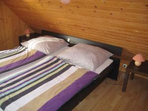 1 dormitorio con 1 cama con pared de madera en Apartment in Fuhlendorf 2747, en Gutglück