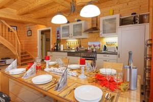 a kitchen with a large wooden table with plates and wine glasses at Holiday home in Zempin (Seebad) 3239 in Zempin