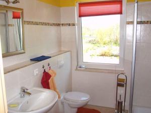 ein Bad mit einem WC, einem Waschbecken und einem Fenster in der Unterkunft Holiday home in Gustow/Insel Rügen 3012 in Gustow