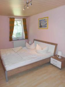 ein Schlafzimmer mit einem großen Bett mit weißer Bettwäsche und Kissen in der Unterkunft Apartment Sayda 1 in Pilsdorf