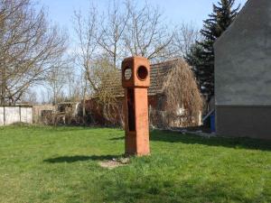 einen Uhrturm im Gras im Hof in der Unterkunft Apartment in Küstriner Vorland 2607 in Manschnow