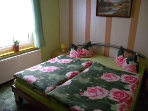 ein Schlafzimmer mit einem Bett mit rosa Blumen drauf in der Unterkunft Apartment Kamminke 2 in Kamminke
