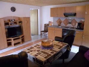 ein Wohnzimmer mit einem Tisch und einer Küche in der Unterkunft Apartment Kamminke 2 in Kamminke