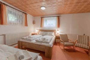 a bedroom with two beds and a chair in it at Apartment Svoboda nad upou 2 in Svoboda nad Úpou