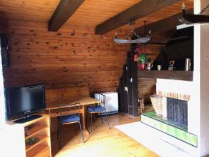Habitación con pared de madera, mesa y TV. en Holiday home Strazne - Riesengebirge 2326, en Strážné