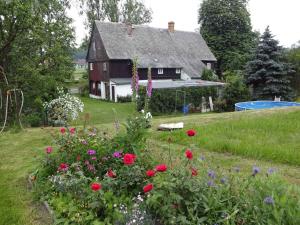 une maison avec un jardin fleuri devant elle dans l'établissement Rekreacni dum s velkou zahradu a venkovnim bazen, à Frýdlant