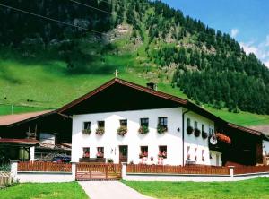 ein weißes Gebäude mit Blumenkästen an den Fenstern in der Unterkunft Apartment in Schmirn/Tirol 717 in Hochmark