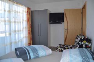 a bedroom with a bed and a chair and a television at Apartment in Serfaus/Ötztal 510 in Serfaus