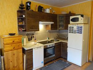 a kitchen with a white refrigerator and wooden cabinets at Studio in Bad Aussee - Steiermark 428 in Bad Aussee