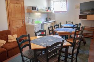 a dining room with tables and chairs and a kitchen at Apartment Harrachov 6 in Nový Svět