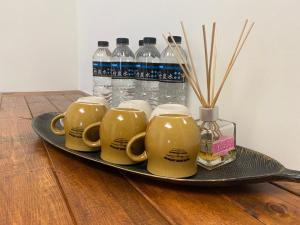 a tray with four cups and bottles of water at 舞艾湖民宿 in Hsing-wen