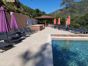 a swimming pool with chairs and umbrellas next to a swimming pool at Casa Del Torrente in Porto Ota