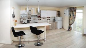 a kitchen with a counter and two bar stools at Квартири подобово Івано-Франківська Nice apartments for booking in Ivano-Frankivsk