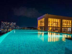 a large swimming pool in front of a building at night at MB GALLERY CHATAN by THE TERRACE HOTELS in Chatan