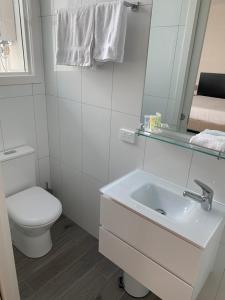 een witte badkamer met een toilet en een wastafel bij BENDIGO HIGH ST APARTMENTS with KING BED-COURTYARD-KITCHEN-REFURBISHED 2022 in Bendigo
