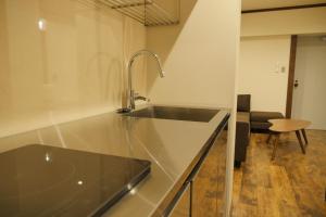 une cuisine avec un évier et un plan de travail dans l'établissement Hotel S-Presso Ebisu, à Osaka