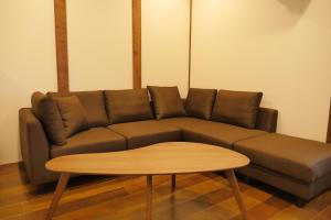 - un canapé brun avec une table basse dans l'établissement Hotel S-Presso Ebisu, à Osaka