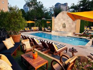 a pool with a bunch of chairs and a table at Hotel ZaZa Dallas in Dallas