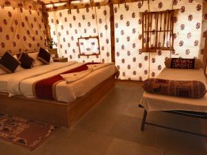 a bedroom with two beds and a chair in it at Aroma Desert Safari Camp in Sām