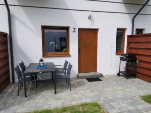 a patio with a table and chairs and a grill at Domki LUNA in Sarbinowo