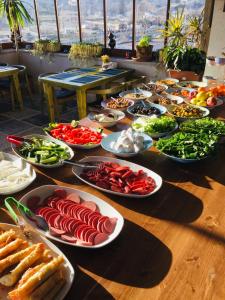 una tavola piena di piatti da mangiare su un tavolo di Caravanserai Inn Hotel a Göreme