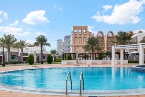 a large swimming pool with a large clock in the middle of it at FAM Living - Sarai Villas in Dubai