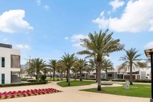 a park with palm trees and a building at FAM Living - Sarai Beach Villas - Palm Jumeirah - Families Only in Dubai
