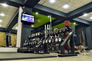 a gym with a bunch of dumbbells and a tv at Clarks Inn Express, Jammu in Jammu