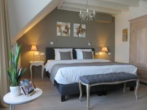 a large bedroom with a large bed and a chandelier at B&B De Goede 13 in Bruges