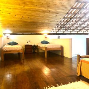 a room with two beds and a wooden ceiling at Casa Bromélia Green in Itacaré