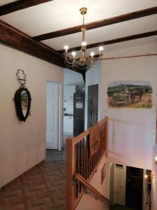 pasillo con escalera y lámpara de araña en Apartament w Karkonoszach Stary Młyn, en Kowary