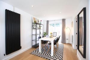 a dining room with a white table and black and white rug at Stylish Cambridge City Pad in Chesterton