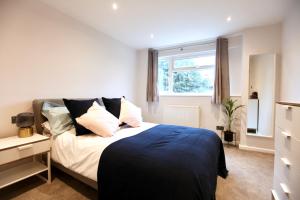 una camera da letto con letto, cuscini e finestra di Stylish Cambridge City Pad a Chesterton