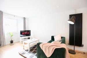 a living room with a green couch and a table at Stylish Cambridge City Pad in Chesterton +12 photos