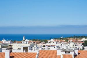 a view of a city with white buildings and the ocean at Lighthouse View in Cascais in Cascais