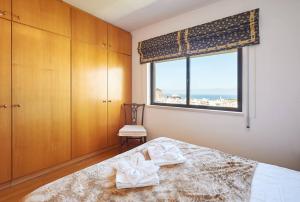 a bedroom with a bed and a window with the ocean at Lighthouse View in Cascais in Cascais