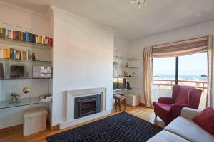 a living room with a couch and a fireplace at Lighthouse View in Cascais in Cascais