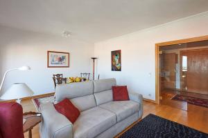a living room with a gray couch and red pillows at Lighthouse View in Cascais in Cascais