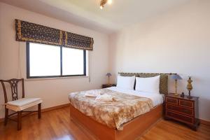a bedroom with a bed and a chair and a window at Lighthouse View in Cascais in Cascais