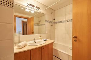a bathroom with a sink and a mirror and a tub at Lighthouse View in Cascais in Cascais