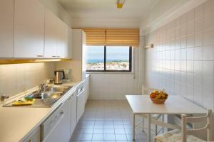 a kitchen with a sink and a table with a bowl of fruit at Lighthouse View in Cascais in Cascais