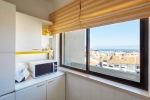a kitchen with a window and a microwave at Lighthouse View in Cascais in Cascais