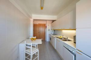 a kitchen with white cabinets and a white chair in it at Lighthouse View in Cascais in Cascais