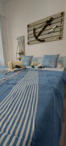 a bed with a blue and white striped blanket on it at Symi . VILLA CALME (Sur la Mer). in Symi
