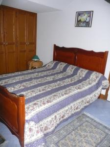 a bedroom with a bed with a blue comforter at gite la chapelle in Nailhac